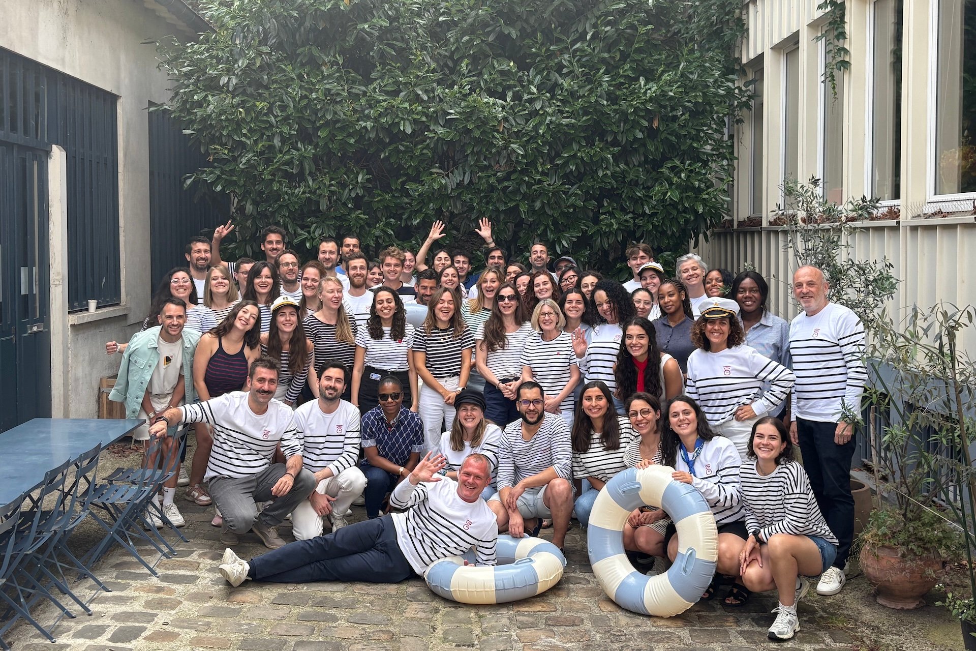 Group of people in striped shirts posing outdoors.
