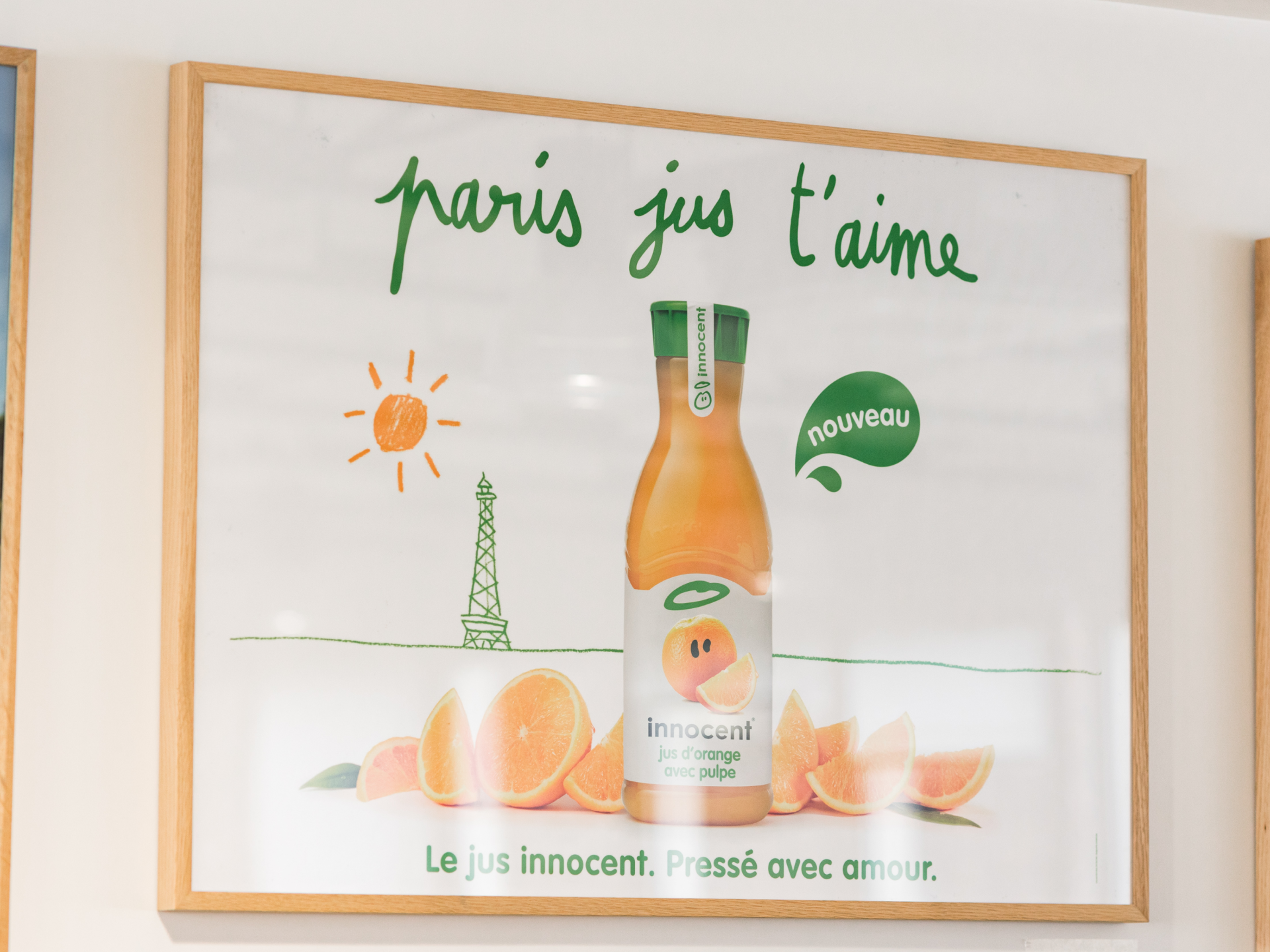 Innocent juice ad with orange slices, sun, Eiffel Tower, and French text.