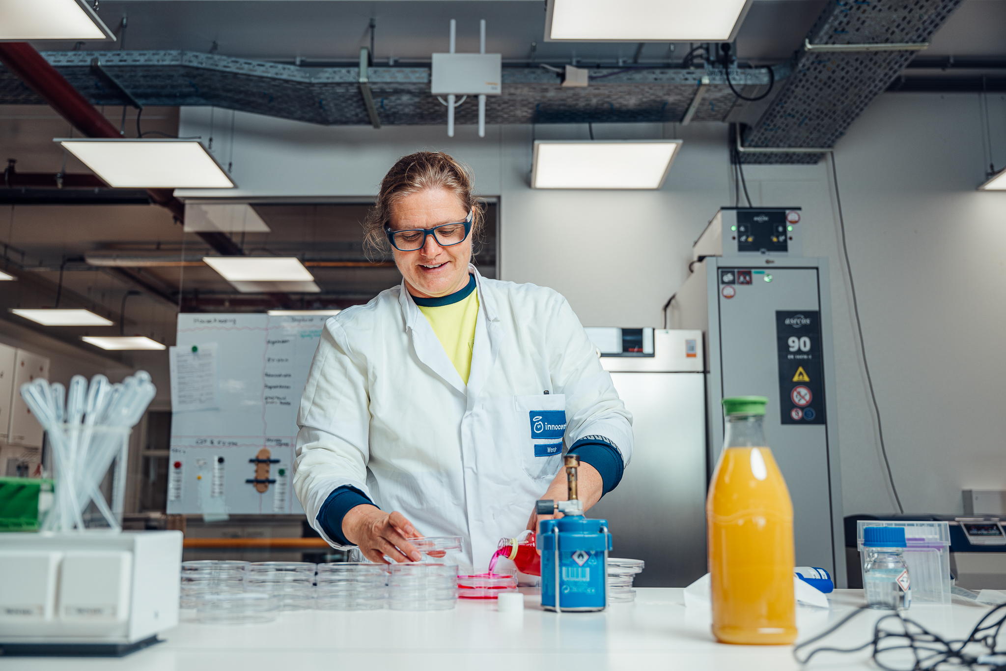 Scientist in protective glasses working in a laboratory setting.