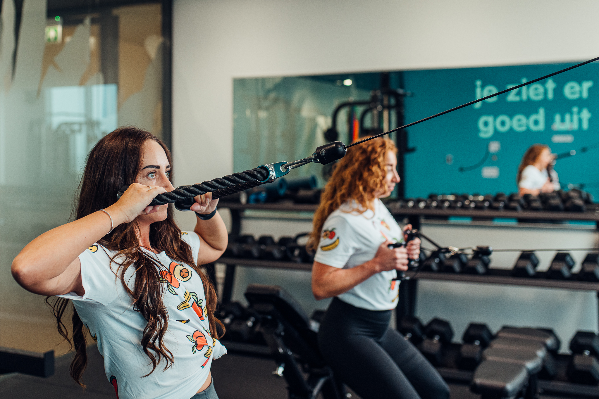 Women using workout equipment at the gym.